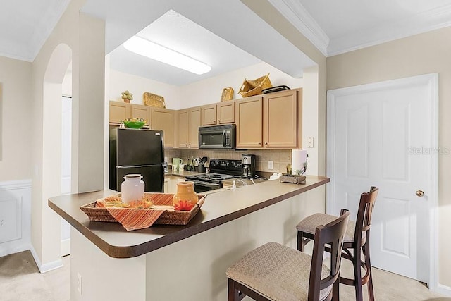 12843 Madison Pointe Cir Unit 107, Orlando, FL 32821 - kitchen featuring black appliances, a kitchen breakfast bar, crown molding, arched walkways, and decorative backsplash