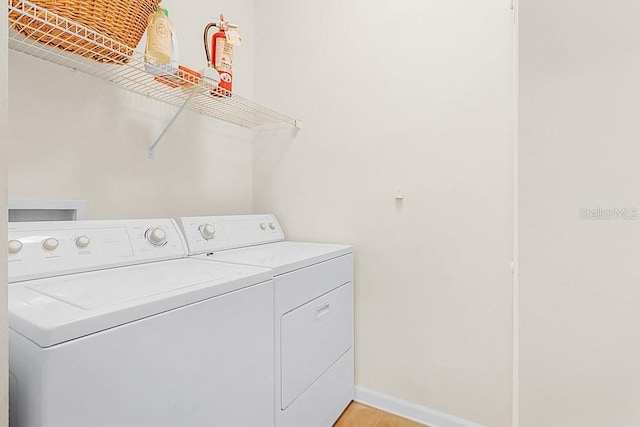 12843 Madison Pointe Cir Unit 107, Orlando, FL 32821 - laundry room with washing machine and dryer and light wood-style flooring