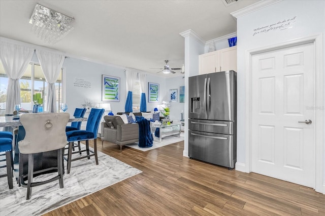 dining space with crown molding, ceiling fan, and hardwood / wood-style flooring