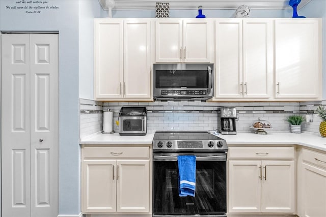 kitchen with tasteful backsplash, crown molding, white cabinetry, and appliances with stainless steel finishes