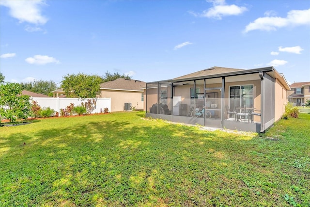 rear view of property featuring a lawn and a sunroom