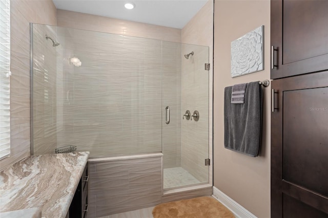 bathroom with a shower with door and vanity