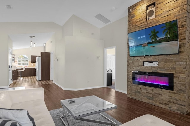 living room featuring a fireplace, high vaulted ceiling, and wood-type flooring