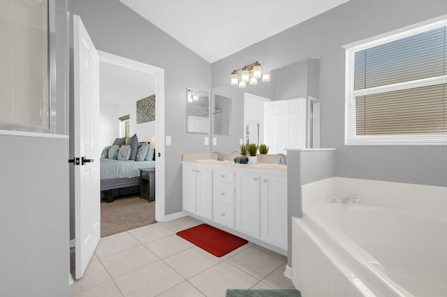 bathroom with tile patterned flooring, a relaxing tiled tub, vanity, and vaulted ceiling