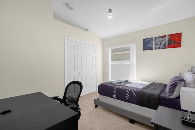 bedroom featuring a closet, light colored carpet, and lofted ceiling