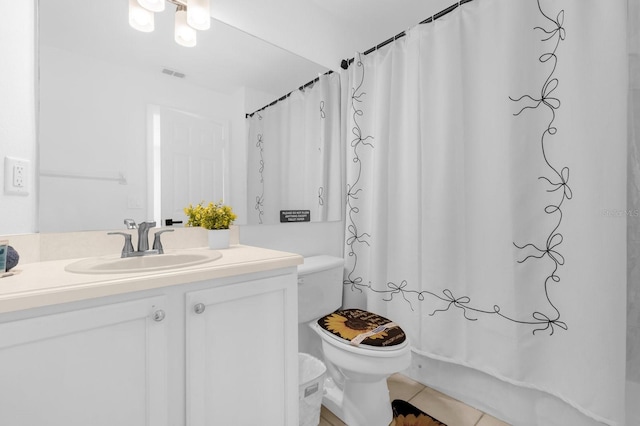 bathroom with tile patterned flooring, vanity, and toilet