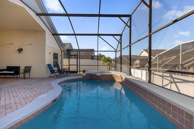 view of swimming pool with glass enclosure, a patio area, and an in ground hot tub