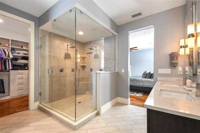 bathroom with vanity, a shower with door, and ceiling fan