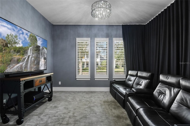 carpeted home theater room featuring a chandelier