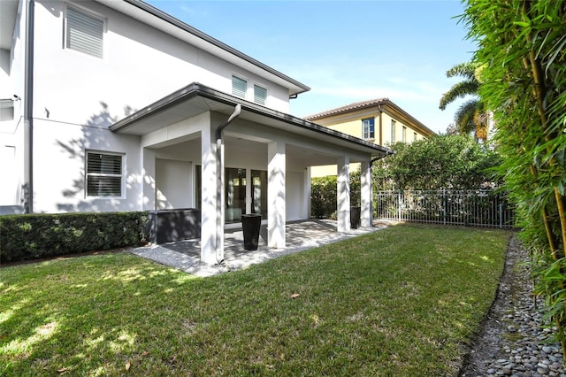 rear view of property featuring a patio area and a yard