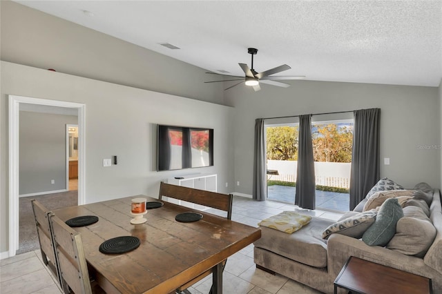 tiled living room featuring a textured ceiling, ceiling fan, and lofted ceiling