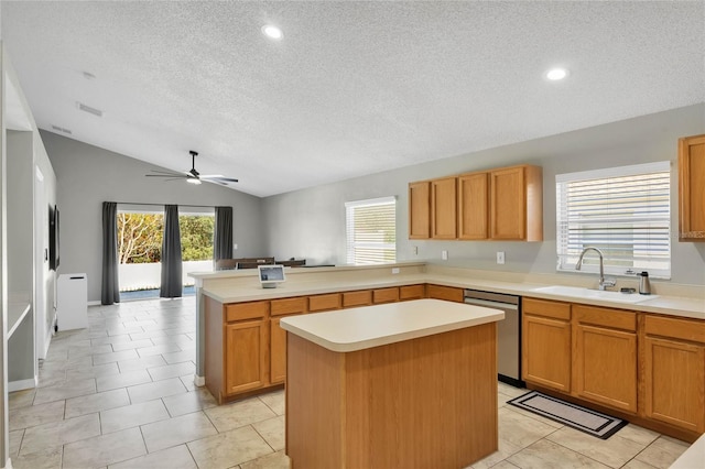 kitchen with ceiling fan, sink, dishwasher, a kitchen island, and lofted ceiling