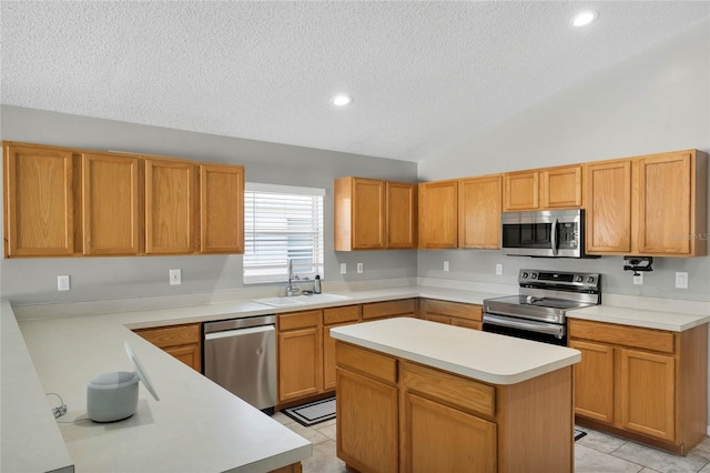 kitchen featuring appliances with stainless steel finishes, vaulted ceiling, sink, light tile patterned floors, and a kitchen island