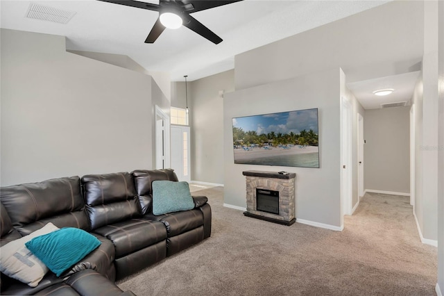 living room featuring a fireplace, ceiling fan, and light carpet