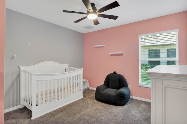 bedroom featuring carpet flooring, ceiling fan, multiple windows, and a nursery area