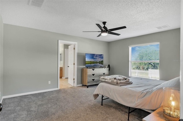 bedroom with a textured ceiling, light colored carpet, and ceiling fan