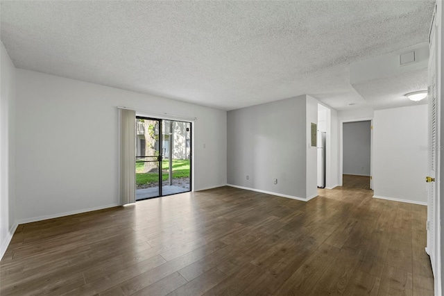 spare room with a textured ceiling and dark hardwood / wood-style floors