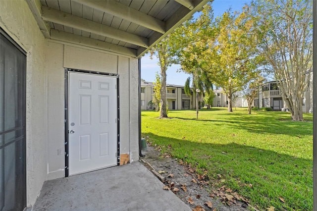 view of exterior entry with a lawn