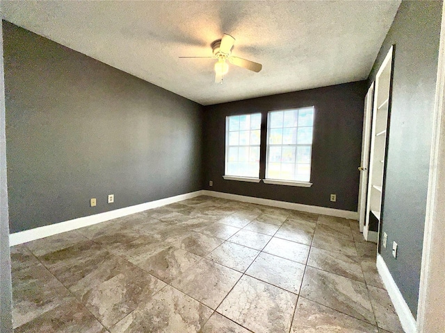 unfurnished room with ceiling fan and a textured ceiling