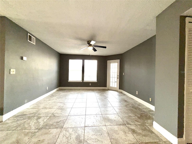 unfurnished room featuring ceiling fan, light tile patterned floors, and a textured ceiling