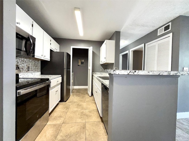 kitchen with backsplash, light stone counters, stainless steel appliances, light tile patterned floors, and white cabinets