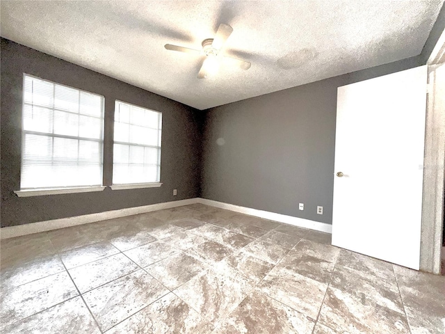 empty room featuring ceiling fan and a textured ceiling