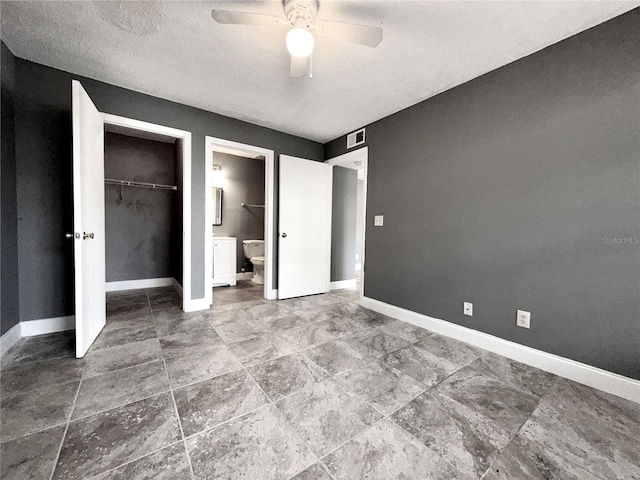 unfurnished bedroom featuring a textured ceiling, a closet, ensuite bath, and ceiling fan