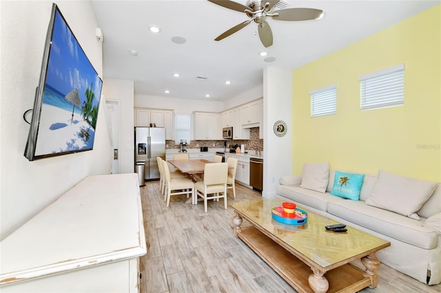 living room with ceiling fan and light hardwood / wood-style flooring