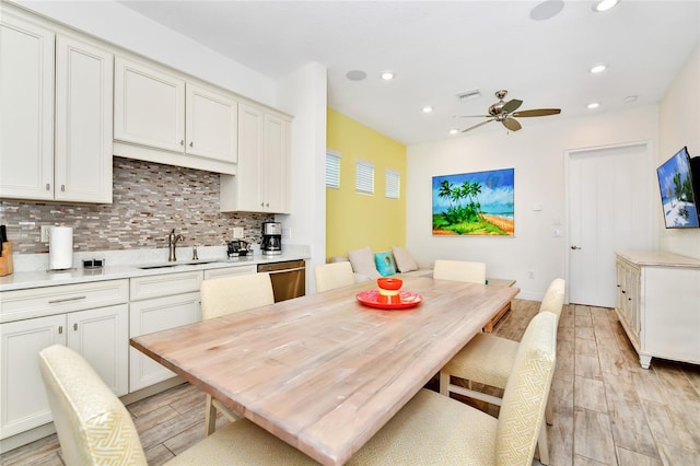 dining space featuring ceiling fan, light wood-type flooring, and sink