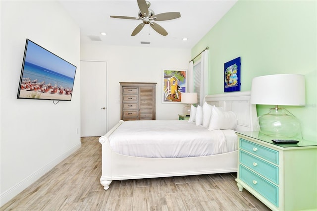 bedroom with light hardwood / wood-style flooring and ceiling fan