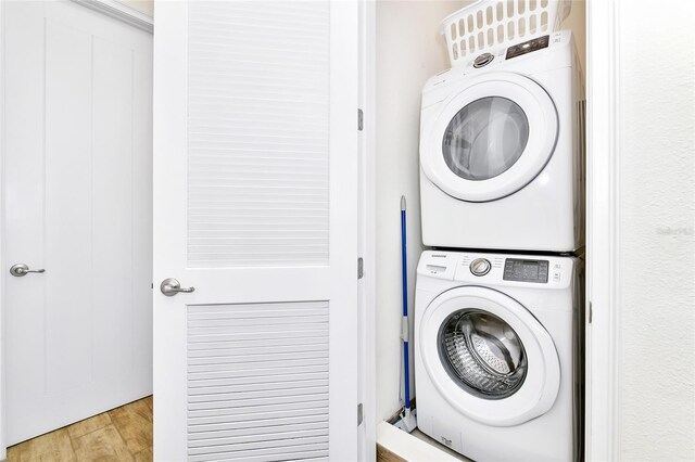 washroom featuring light hardwood / wood-style flooring and stacked washing maching and dryer