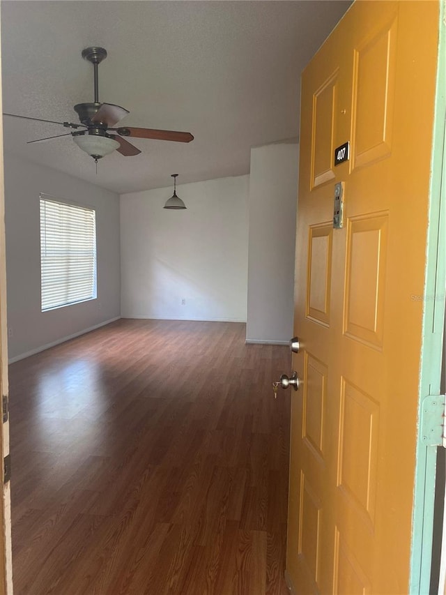 unfurnished room featuring dark hardwood / wood-style floors and ceiling fan