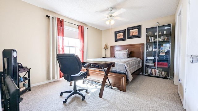 bedroom featuring light carpet, a textured ceiling, and ceiling fan