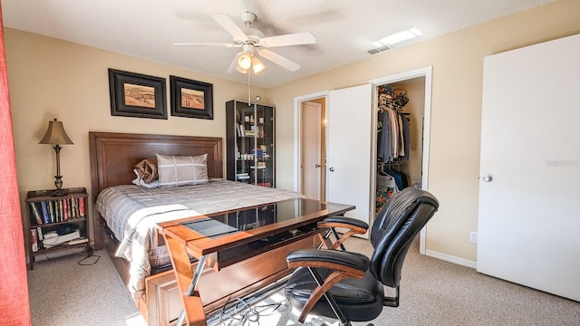 carpeted bedroom featuring ceiling fan, a spacious closet, and a closet