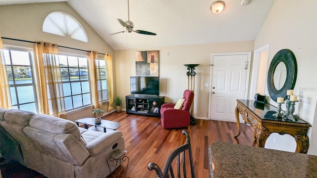 living room with a textured ceiling, a wealth of natural light, dark wood-type flooring, and ceiling fan