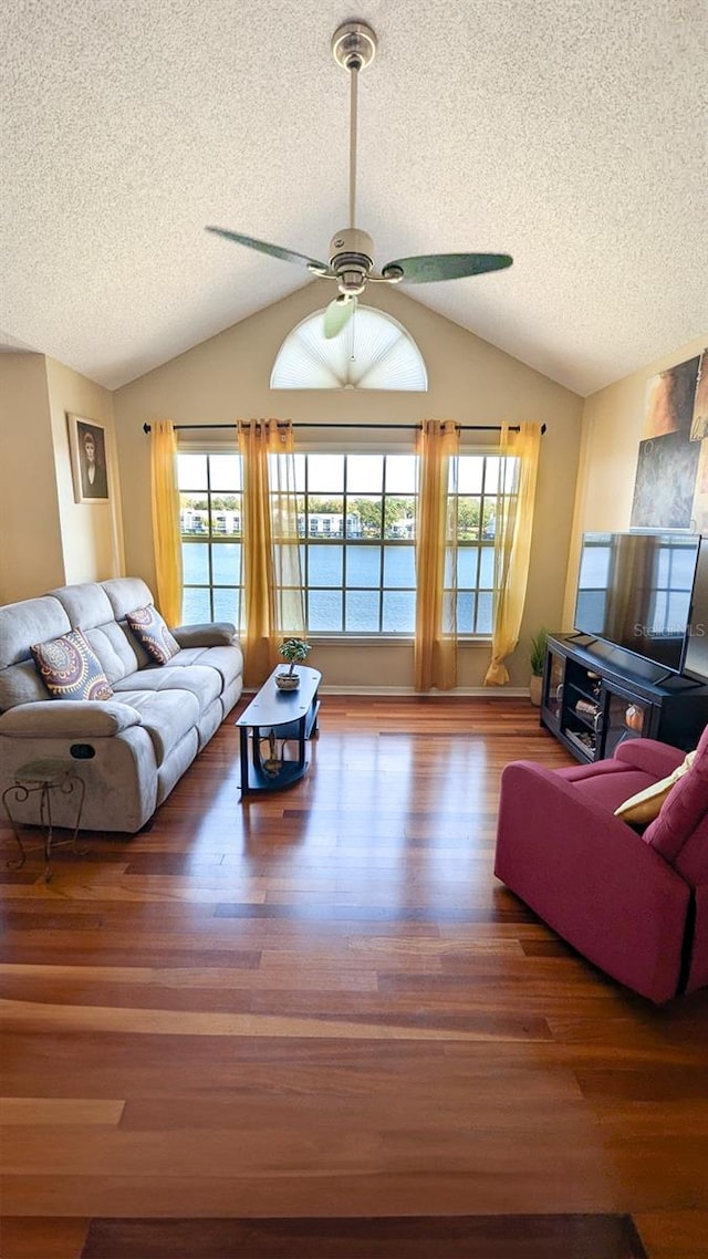 living room featuring a textured ceiling, dark hardwood / wood-style flooring, ceiling fan, and lofted ceiling