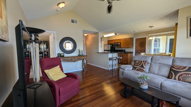 living room with a textured ceiling, dark wood-type flooring, and vaulted ceiling