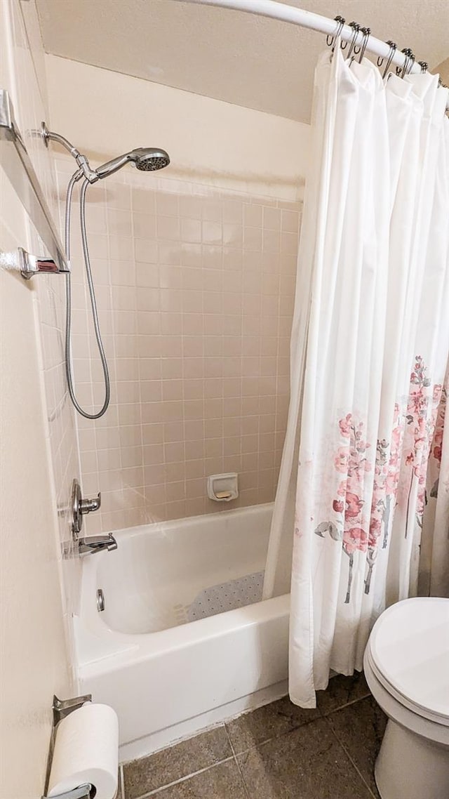 bathroom with tile patterned flooring, shower / bath combo, and toilet