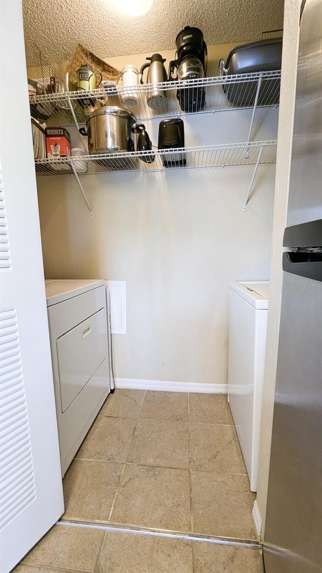 laundry room featuring a textured ceiling and washer / clothes dryer