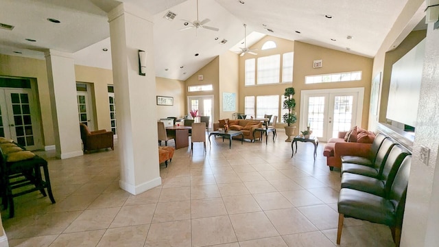 tiled living room with ceiling fan, ornate columns, high vaulted ceiling, and french doors