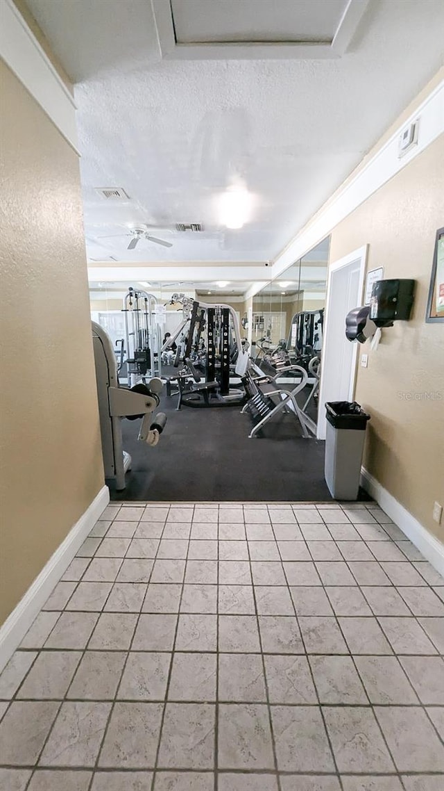 workout area with ceiling fan and a textured ceiling