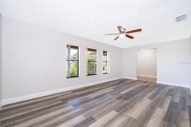 spare room featuring a textured ceiling, ceiling fan, and dark wood-type flooring