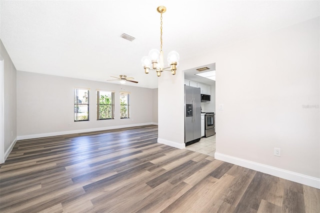 interior space with wood-type flooring and ceiling fan with notable chandelier