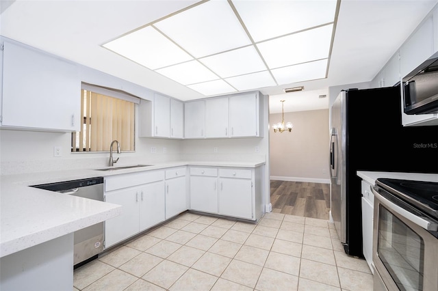 kitchen featuring sink, a chandelier, pendant lighting, white cabinets, and appliances with stainless steel finishes