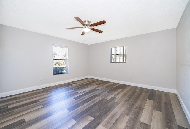 empty room with a textured ceiling, ceiling fan, and dark hardwood / wood-style floors