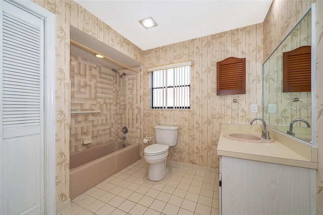 full bathroom with tile patterned floors, vanity, tiled shower / bath combo, and toilet