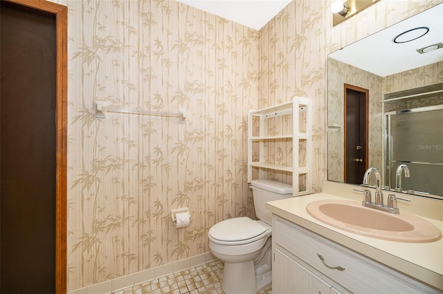 bathroom featuring tile patterned flooring, vanity, toilet, and an enclosed shower