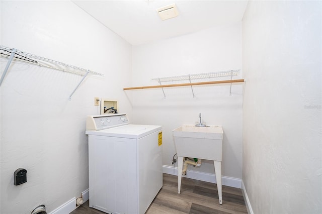 clothes washing area with hardwood / wood-style floors, sink, and washer / clothes dryer