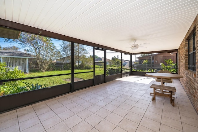 unfurnished sunroom featuring ceiling fan