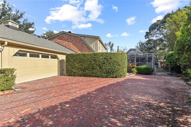 view of side of property with glass enclosure and a garage